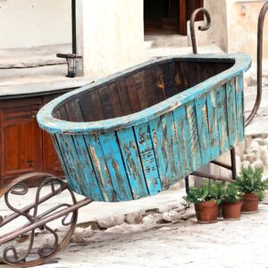 A wooden tub on wheels in the middle of a courtyard.