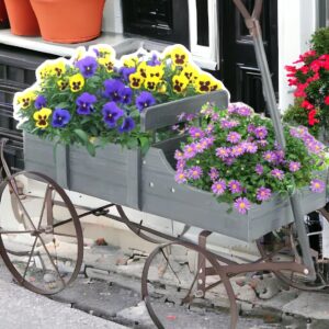 A flower cart with flowers in it on the side of the road.