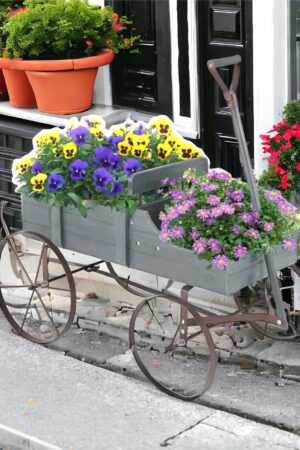 A flower cart with flowers in it on the side of the road.