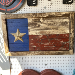 A wooden texas flag hanging on the wall.