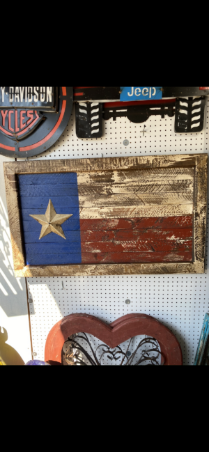 A wooden texas flag hanging on the wall.