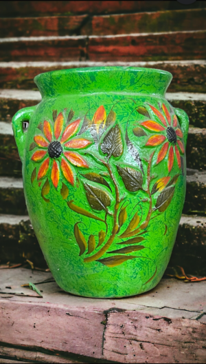 A green vase with flowers and leaves painted on it.